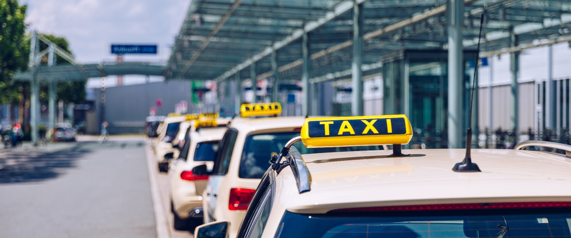 Taxischild auf dem Dach eines Fahrzeugs. Taxis auf der Straße, die auf Fahrgäste warten. Selektiv fokussiertes Bild. Wartende Taxis in der Stadt.
